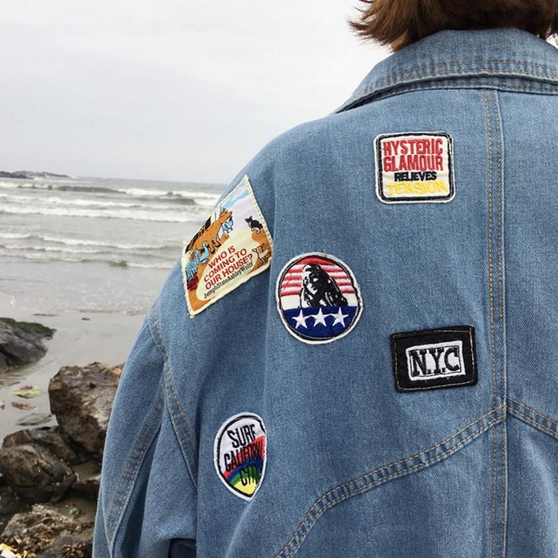 R&G Boutique Esther denim jacket hanging on a hook, showcasing classic blue denim with front pockets and button closure.