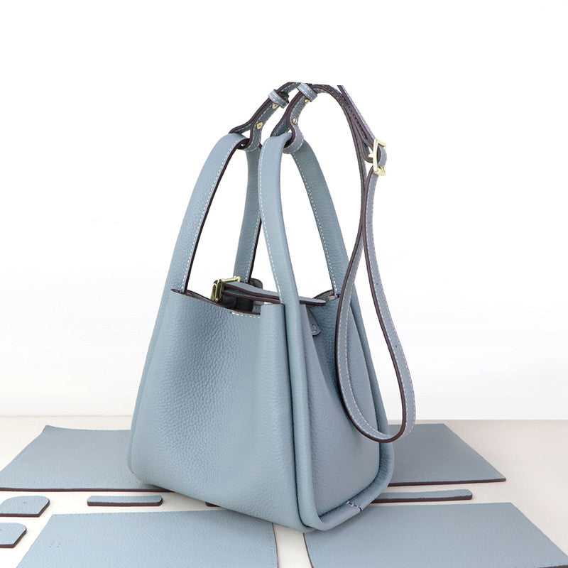 Hand sewing leather bag with leather craft tools, showcasing handmade leather goods by R&G Boutique for DIY leather making.
