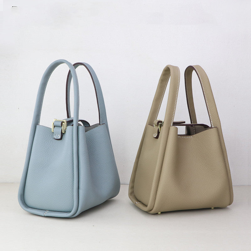 Hand sewing leather bags with tools and leather pieces for DIY handmade leather goods by R&G Boutique.